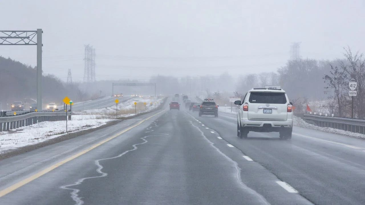 A foggy multi-lane winter view of Ontario Highway 412 southbound in Whitby; no people present