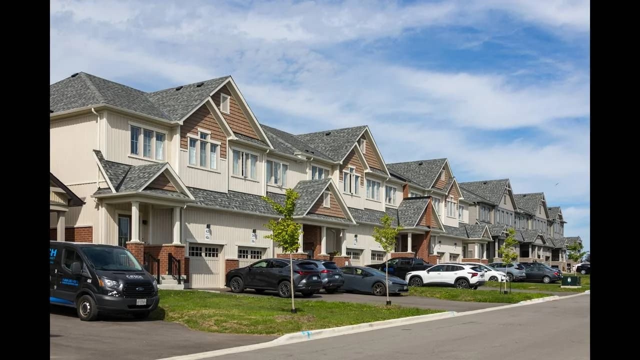 Residential street with suburban townhouses and parked cars in Durham Region; no people visible