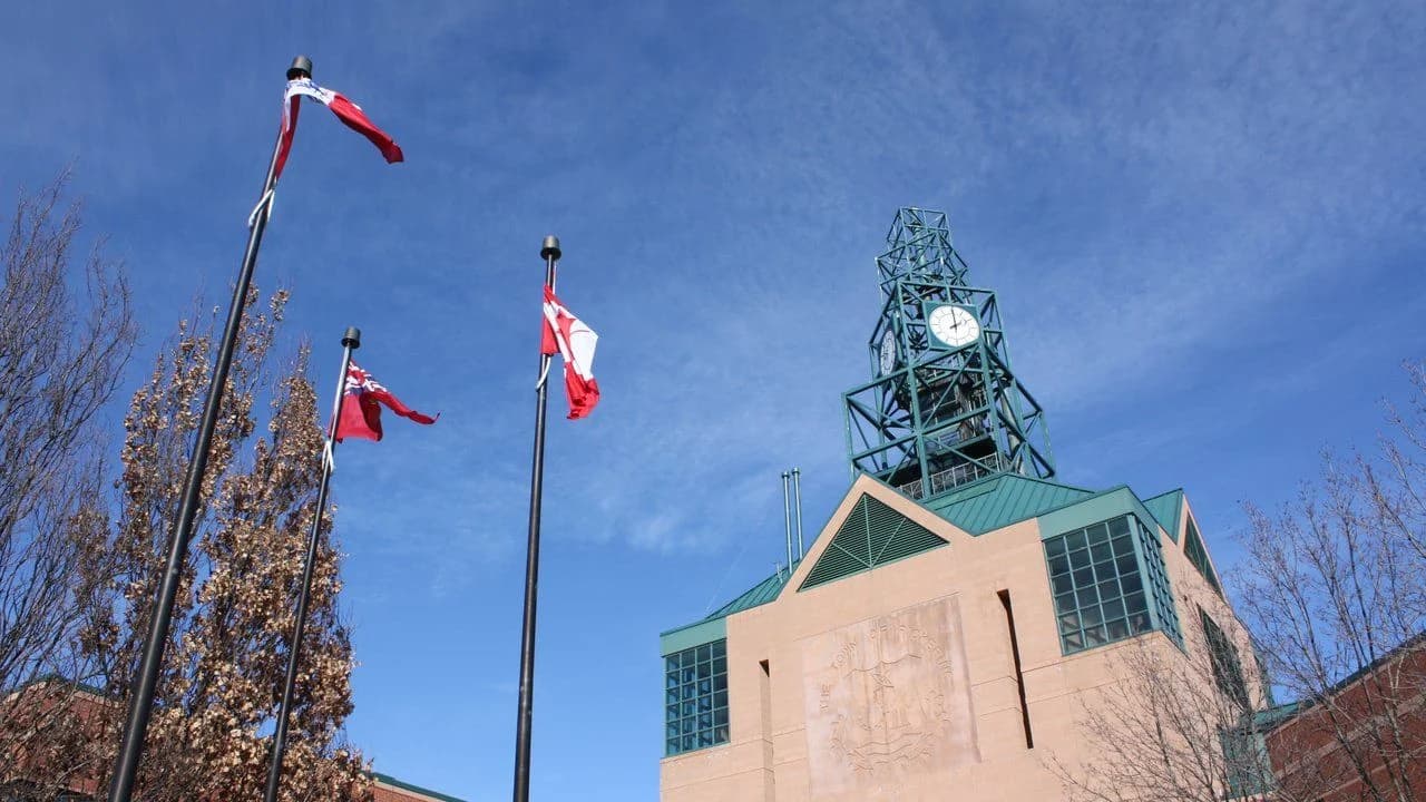 Pickering Civic Centre clock tower with flags flying; no people visible.