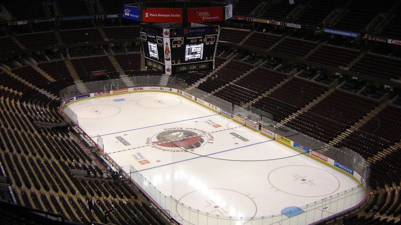 An empty indoor ice hockey arena viewed from the stands; no people visible