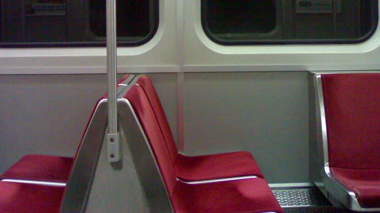 Interior of an empty TTC subway car with red seats and windows; no people visible