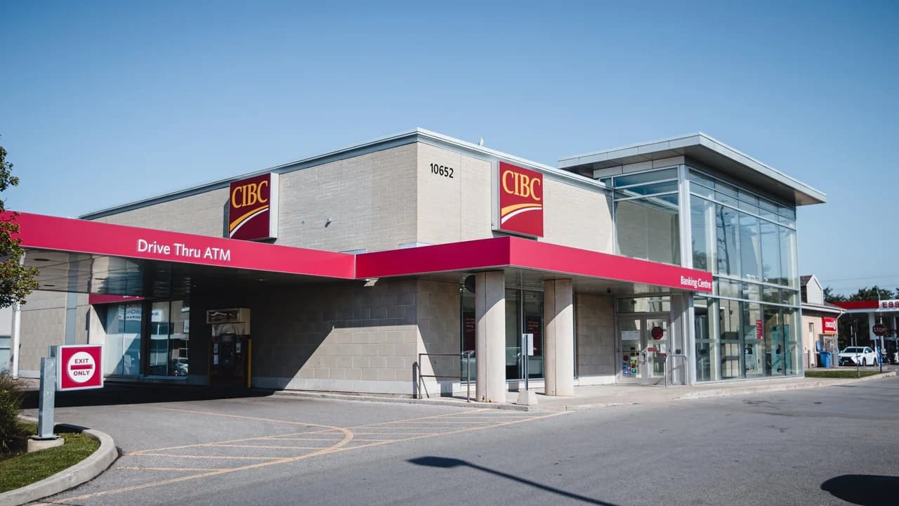 A CIBC bank branch building with a drive-thru ATM under a clear sky; no people visible.