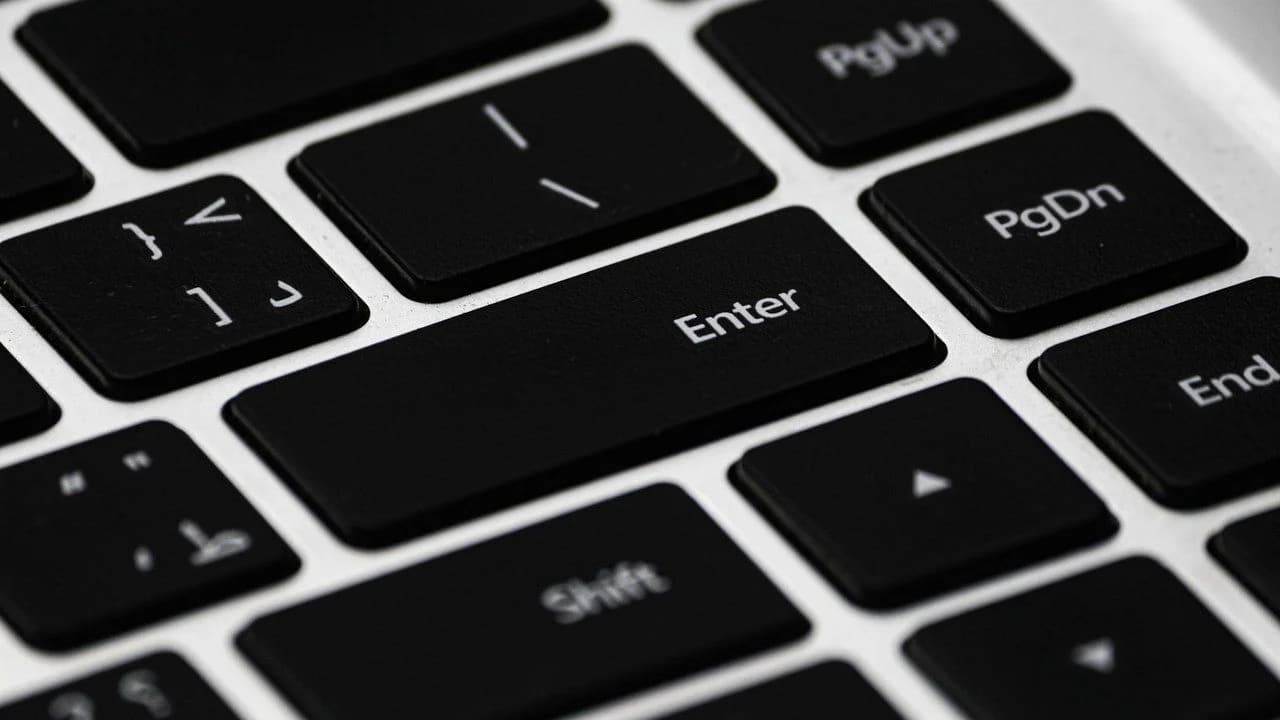 Close-up of a black laptop keyboard showing the Enter, Shift, PageUp, PageDown and arrow keys; no people.